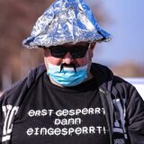 Ein Demonstrant trägt einen Aluhut