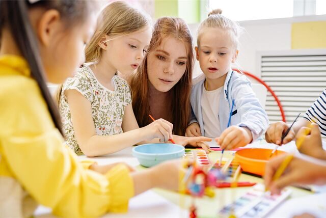 Kinder malen mit einer Erzieherin in einem Kindergarten (Symbolbild).