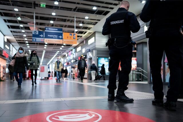 Mitarbeiter des Ordnungsamtes stehen am Eingang des Bahnhofs.Mitarbeiter des Ordnungsamtes stehen am Eingang des Bahnhofs.