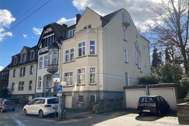 Wohnhäuser und Garagen an der Straße Westerholter Weg in Recklinghausen. Davor parken drei Autos.