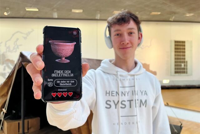 Ein Junge hält ein Smartphone in der Hand. Darauf ist die neue App des Römermuseums geöffnet.