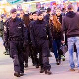 Polizisten gehen über das mit Menschen gefüllte Gelände der Recklinghäuser Palmkirmes.