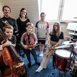 Familie Putzke steht mit diversen Instrumenten im Musikzimmer ihrer Altbauwohnung in Recklinghausen.