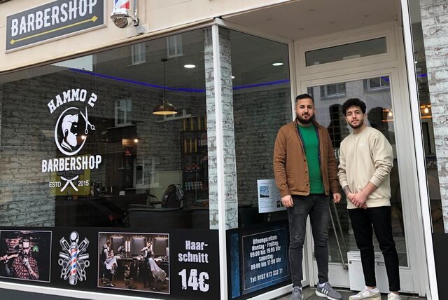 Die Inhaber des neuen Barbershops stehen vor dem neuen Geschäft.