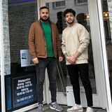 Die Inhaber des neuen Barbershops stehen vor dem neuen Geschäft.