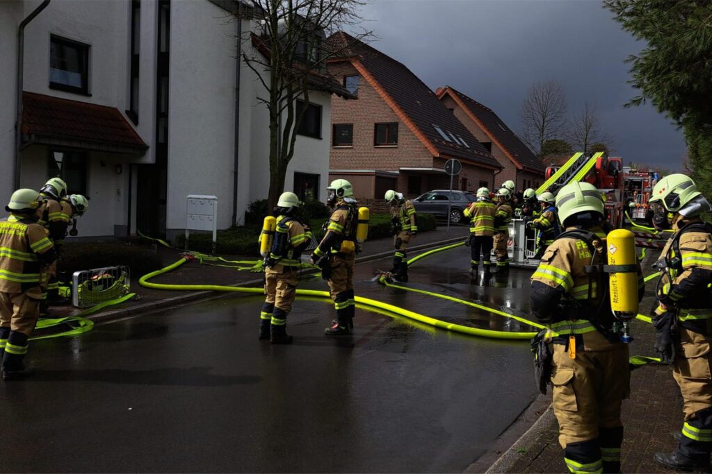 Feuerwehrleute stehen vor dem brennenden Haus. Feuerwehrleute stehen vor dem brennenden Haus.