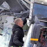 Der Mitarbeiter des Abschleppdienstes befreit lose Teile aus dem Bus-Wrack.