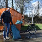 Ein Mann steht mit einem Fahrrad vor einem Müllcontainer in Oer-Erkenschwick.