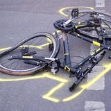 Zu sehen ist ein demoliertes, auf der Straße liegendes Fahrrad, dessen Umriss mit Kreide markiert worden ist.