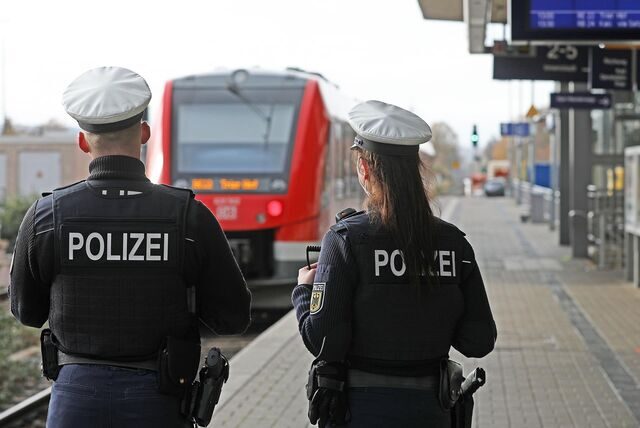 Zwei Bundespolizisten stehen auf einem Bahnsteig.