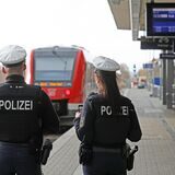 Zwei Bundespolizisten stehen auf einem Bahnsteig.