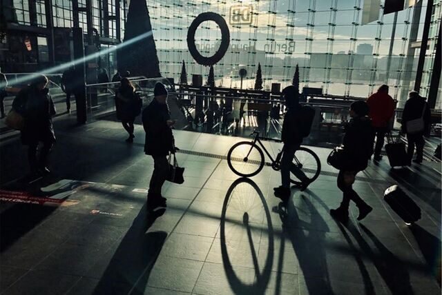 Reisende gehen im Licht der Morgensonne durch den Hauptbahnhof.