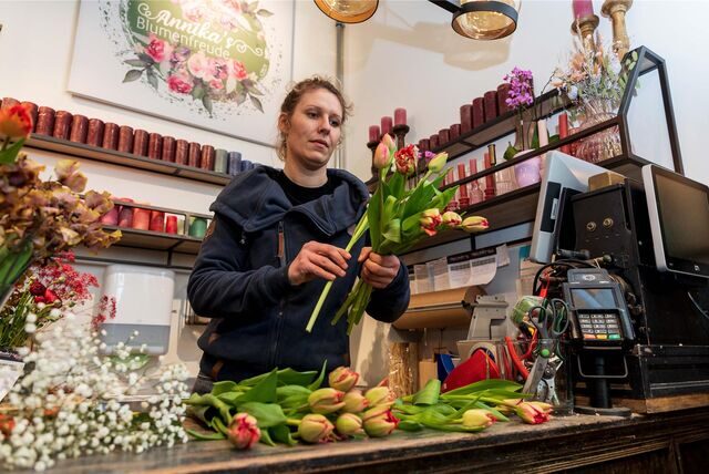 Eine Floristin arrangiert Tulpen zu einem Strauß.