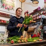 Eine Floristin arrangiert Tulpen zu einem Strauß.