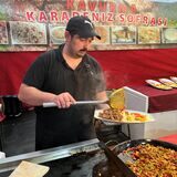 Ein Mann bereitet auf dem Festi Ramazan Dortmund ein Gericht zu