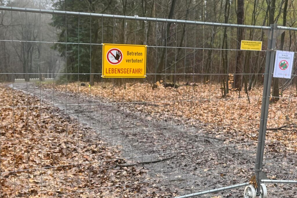 Ein Absperrgitter blockiert einen Waldweg. Ein Hinweisschild warnt vor Lebensgefahr. Ein Absperrgitter blockiert einen Waldweg. Ein Hinweisschild warnt vor Lebensgefahr.