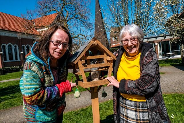 Monika Wagner-van der Straten und Andrea Kurbjuhn-Ebmeier stehen in Recklinghausen auf einer Wiese neben einem Vogelhäuschen.