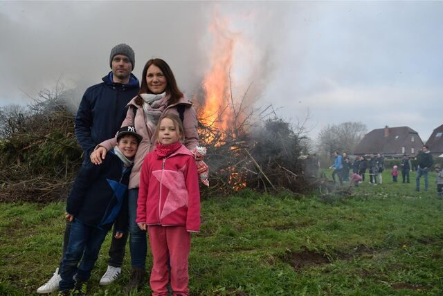 Eine vierköpfige Familie steht vor einem Osterfeuer.
