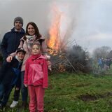 Eine vierköpfige Familie steht vor einem Osterfeuer.