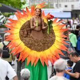 Eine Sonnenblumen-Stelzenläuferin lacht in die Kamera.