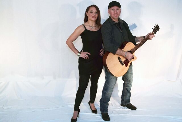 Das Musik-Duo JuicyTones steht vor einer weißen Fotokulisse