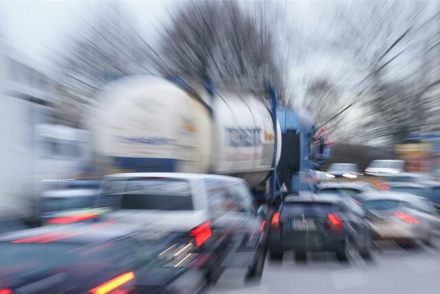 Autos und Lastwagen im Berufsverkehr im Stau auf einer mehrspurigen Straße.