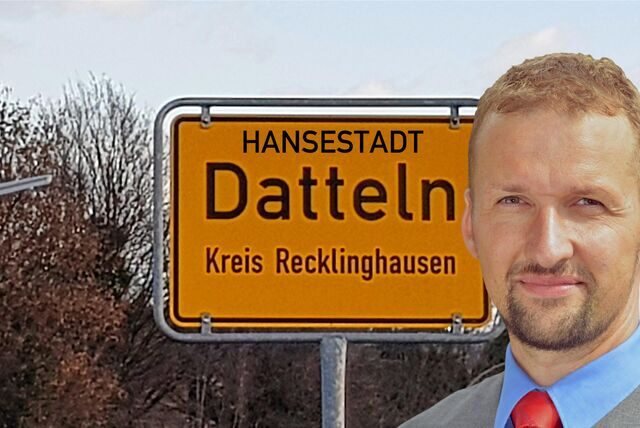 Ein Mann steht vor einem Ortsschild.