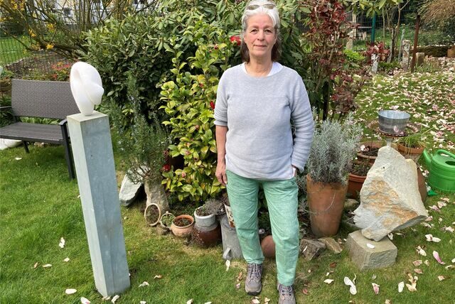 Künstlerin Judith Hupel steht neben Arbeiten in ihrem Skulpturengarten in Recklinghausen.