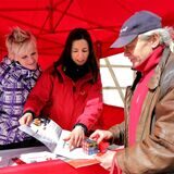 Ein Mann lässt sich an einem Infostand von zwei Frauen beraten.