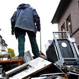 Ein Mann steht auf einem Berg aus Metallschrott.