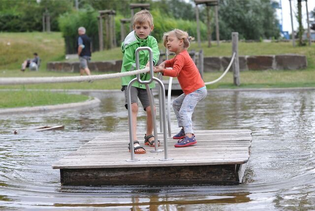Mit vereinten Kräften schaffen es auch jüngere Kinder, das Floß gut über den künstlichen See des Wasserspielplatzes am Schiffshebewerk Henrichenburg zu ziehen.