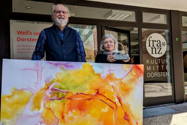 Bernd Saalfeld und Slavica van der Schors vom Kunstverein „Virtuell-Visuell“ zeigen ein Kunstwerk.