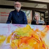 Bernd Saalfeld und Slavica van der Schors vom Kunstverein „Virtuell-Visuell“ zeigen ein Kunstwerk.