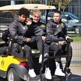Karim Adeyemi, Julian Brandt und Raphael Guerreiro sitzen auf einem Golfcart.
