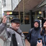 Stadtführer Alfred Stemmler und zwei Teilnehmerinnen einer Stadtführung blicken hoch zu den Fassaden in der Recklinghäuser Altstadt.