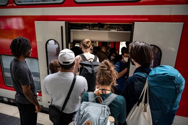 Menschen steigen am Bahnsteig in einen Regionalexpress ein.