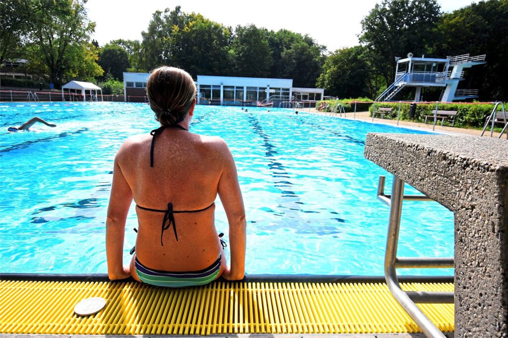 Eine Schwimmerin genießt die Abkühlung am Beckenrand der Mollbeck in Recklinghausen. Eine Schwimmerin genießt die Abkühlung am Beckenrand der Mollbeck in Recklinghausen.