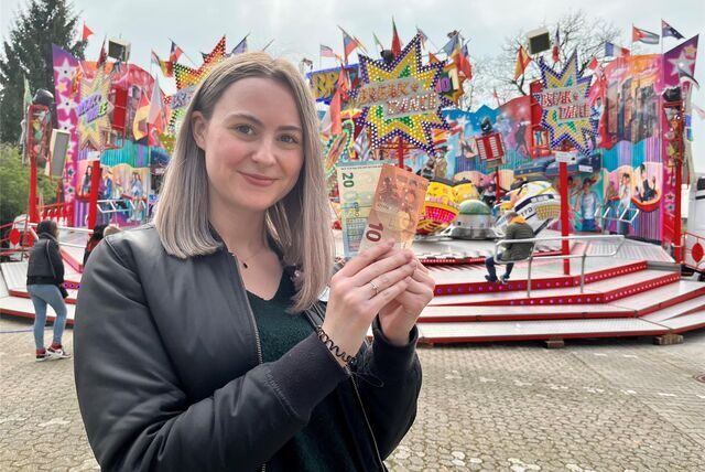 Volontärin Julia Segantini mit 30 Euro in der Hand vor dem Fahrgeschäft Breakdancer auf der Castroper Frühjahrskirmes