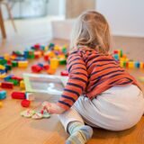 Ein Kind spielt in einer Kita mit bunten Legosteinen.