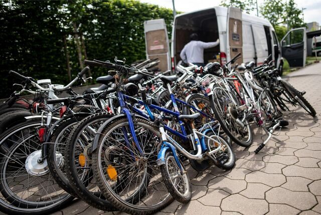 Mutmaßlich gestohlene Fahrräder stehen vor einem Transporter auf dem Gelände eines Polizeipräsidiums.