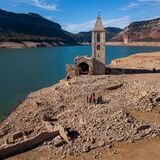 Eine Kirche und die Überreste eines alten Dorfes im Stausee von Sau in Spanien.