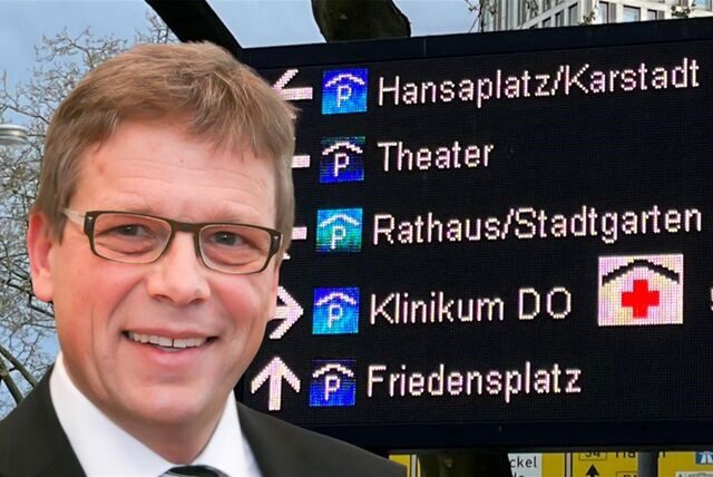 Bau-Dezernent Arnulf Rybicki vor einer Tafel des Parkleitsystems