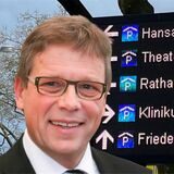 Bau-Dezernent Arnulf Rybicki vor einer Tafel des Parkleitsystems