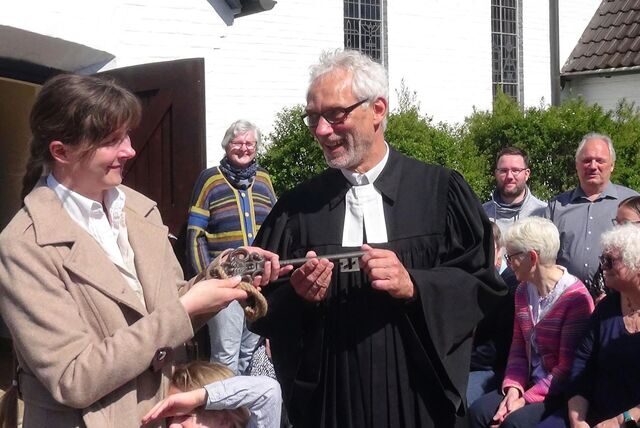 Nach dem Entwidmungsgottesdienst übergab Pfarrer Michael Laage umringt von Presbyterium und Vereinsvorstand symbolisch einen großen Schlüssel an die Vorsitzende des Fördervereins Gnadenkirche Wulfen Christine Markowsky.