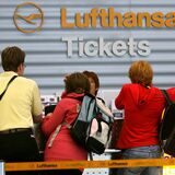 Reisende am Ticketschalter von Lufthansa