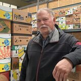 Michael Inhestern steht im Lager der Umwelt-Werkstatt in Datteln. Im Hintergrund sind viele Bananen-Kisten übereinander gestapelt.