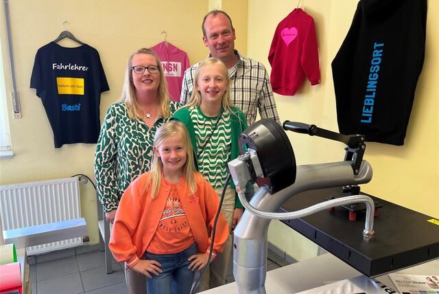 Denise, Laura, Mia und Philipp Schmalöer stehen hinter einer Druckermaschine.