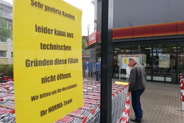 Ein gelbes Schild weist auf die verschobene Eröffnung von Norma hin.