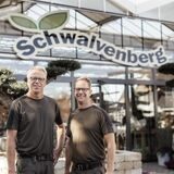 Stefan und Karsten Schwalvenberg stehen zwischen ihren Blumenpflanzen.