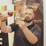 Spirituosen-Experte Sebastian Büssing schüttet aus einer Flasche eine goldene Flüssigkeit in ein Glas.